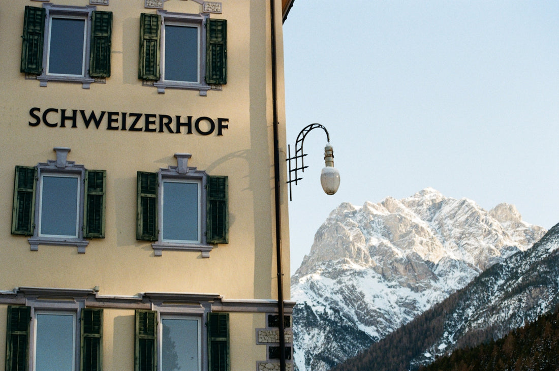 A tall yellow building with a mountain in the background